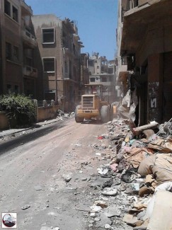 Escavatrici a lavoro per le strade di Homs. 