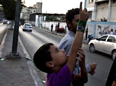 A Palestinian boy points to Israeli drones over Gaza City as eight days of relative calm ended