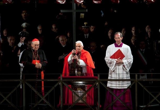 Pope Benedict XVI (C) holds the cross as he leads the Way of the Cross on Good Friday on April 2, 2010 at Rome's Colosseum. AFP PHOTO / ANDREAS SOLARO (Photo credit should read ANDREAS SOLARO/AFP/Getty Images)