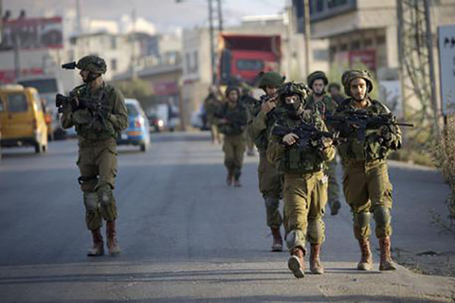 Israeli soldiers patrol during a search for the suspected Palestinian killers of two Jewish settlers in the West Bank city of Nablus, Saturday, Oct. 3, 2015. An Israeli couple was killed in a drive-by shooting driving on an West Bank road Thursday. (ANSA/AP Photo/Majdi Mohammed)