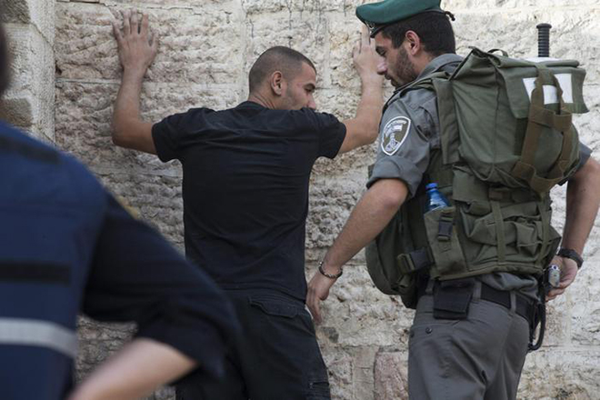 epa04976425 An Israeli policeman checks a Palestinian man at the Damascus Gate of the old city as security measures are increased in Jerusalem, Israel, 13 October 2015. The past 12 days have seen the worst spell of street violence in Israel and the Palestinian areas in years, stirred in part by Muslim anger over perceived changes to the status quo observed at a disputed Jerusalem holy site. Sixteen Palestinians from the West Bank and Jerusalem have been killed, but more than half of them have been attackers shot dead after or during attempts to stab Israelis. EPA/ATEF SAFADI