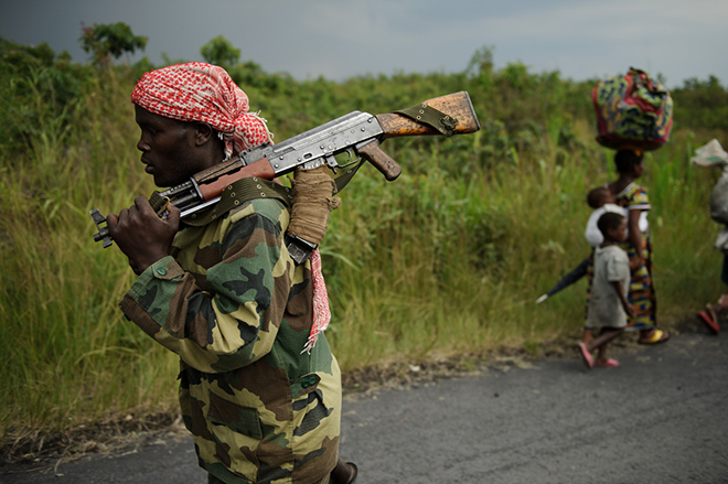 An M23 rebel marches towards the town of Sake, 26km west of Goma, as thousands of residents flee fresh fighting in the eastern Democratic Republic of the Congo town on November 22, 2012. Fighting broke out this afternoon causing people to flee the town and head east, towards Goma, to the camps for the internally displaced in the village of Mugunga. (Phil Moore/Getty Images)