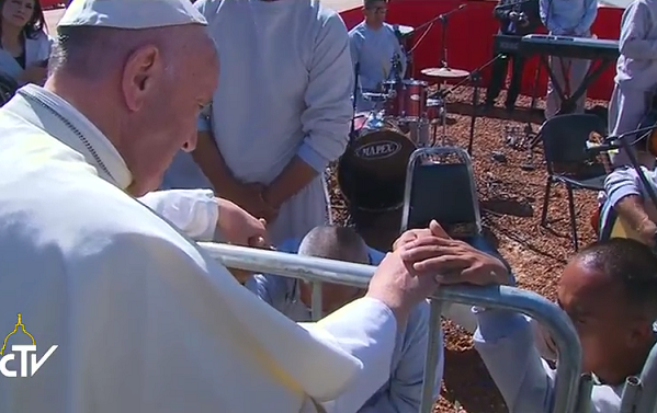 Al termine dell'incontro un momento di preghiera silenzioso con due carcerati che Papa Francesco tiene per mano
