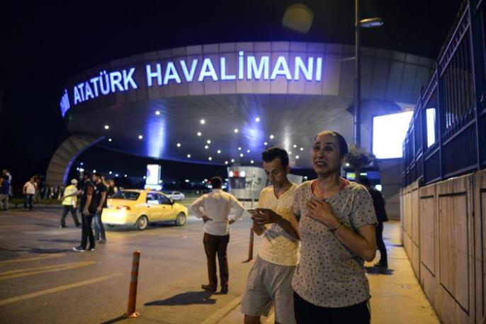 People stand outside Istanbul's Ataturk airport, Tuesday, June 28, 2016. Two explosions have rocked Istanbul's Ataturk airport, killing several people and wounding others, Turkey's justice minister and another official said Tuesday. A Turkish official says two attackers have blown themselves up at the airport after police fired at them. The official said the attackers detonated the explosives at the entrance of the international terminal before entering the x-ray security check. Turkish authorities have banned distribution of images relating to the Ataturk airport attack within Turkey. (ANSA/AP Photo) TURKEY OUT