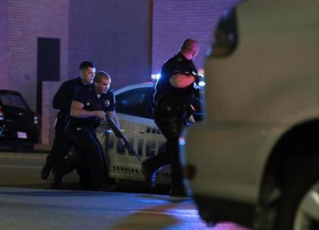 Dallas police respond after shots were fired during a protest over recent fatal shootings by police in Louisiana and Minnesota, Thursday, July 7, 2016, in Dallas. Snipers opened fire on police officers during protests; several officers were killed, police said. (Maria R. Olivas/The Dallas Morning News via AP)