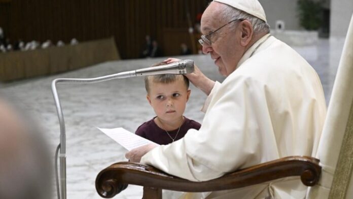 Il Papa accarezza il bimbo che gli si è avvicinato alla fine dell'udienza generale